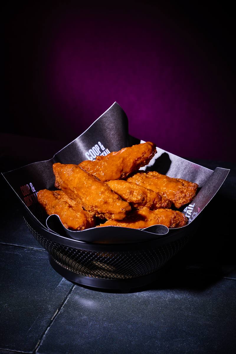 Buffalo chicken tenders piled in a black basket